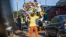 Seorang pedagang kaki lima membawa barang dagangannya di jalan Niamey, Niger (10/7/2019). Nama negara ini diambil dari Sungai Niger. Ibu kotanya ialah Niamey. Niger adalah negara berkembang, dan merupakan negara dengan urutan ke-188 Indeks Pembangunan Manusia PBB. (AFP Photo/Issouf Sanogo)