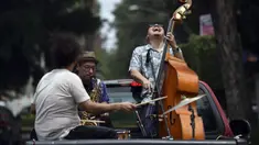 Band Maroto Jazz Trio yang terdiri dari Diego Maroto pada Saxophone, Jorge Molina pada double bass, dan Edy Vega pada drum tampil dari atas sebuah van melewati kawasan Mexico City, Meksiko, 29 Agustus 2020. Penampilan mereka dilakukan di tengah pandemi virus corona COVID-19. (RODRIGO ARANGUA/AFP)