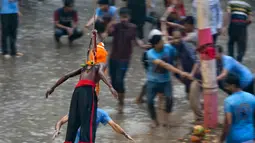 Seorang penganut Hindu tergantung dengan kaitan yang ditusuk di punggungnya saat festival Charak Puja di Dhaka, Bangladesh (14/4). Orang-orang Hindu percaya bahwa festival akan membawa kemakmuran. (AP Photo / A.M. Ahad)