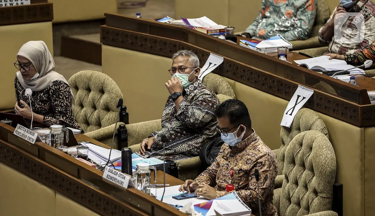 Ketua KPU Arief Budiman (tengah) dan Wakil Ketua KPU Evi Novida Ginting Manik (kiri) saat Rapat Dengar Pendapat dengan Komisi II DPR di Gedung Nusantara, Senayan, Jakarta, Kamis (12/11/2020). Rapat dipimpin Ketua Komisi II DPR Ahmad Doli Kurnia. (Liputan6.com/Johan Tallo)