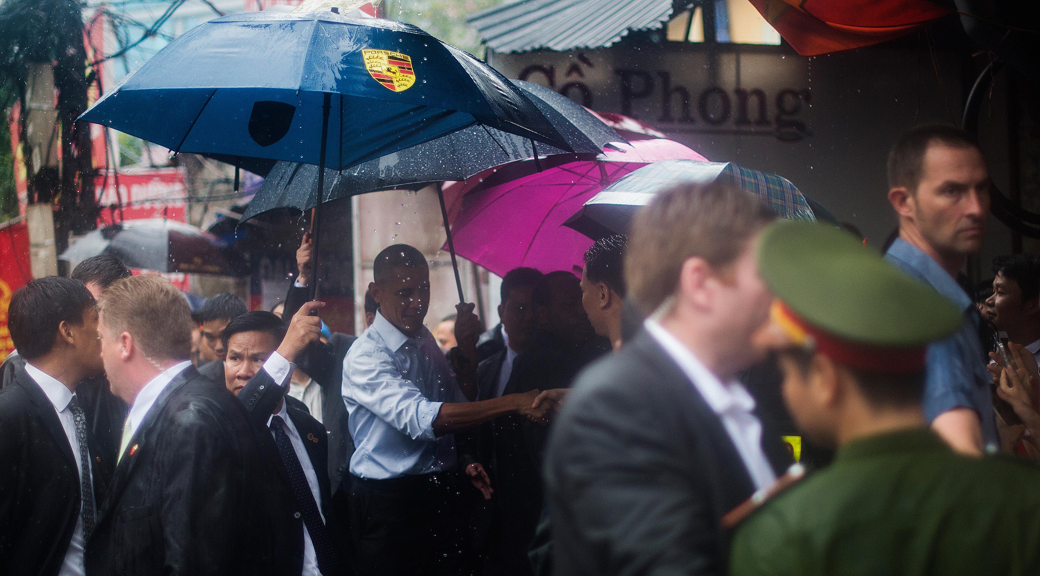 Presiden AS, Barack Obama menyapa warga usai wawancara dengan Anthony Bourdain di area perbelanjaan Hanoi, Vietnam (24/5). Kunjungan Obama ke Vietnam untuk mengakhiri larangan penjualan perlengkapan militer kepada pihak Hanoi. (AFP PHOTO/JIM WATSON)
