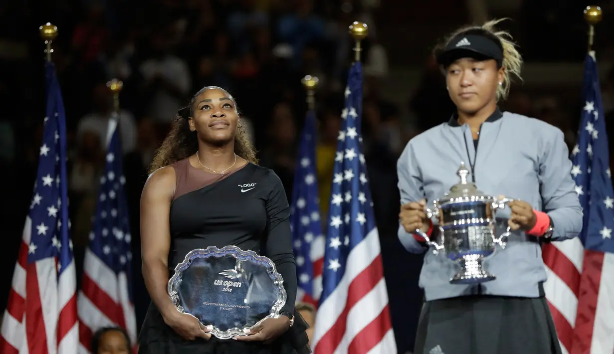 Petenis AS, Serena Williams melihat petenis Jepang, Naomi Osaka saat memegang trofi turnamen AS Terbuka seusai memenangi partai final di Arthur Ashe Stadium, New York, Sabtu (8/9). Naomi Osaka menang dua set dengan skor 6-2 dan 6-4. (AP/Julio Cortez)