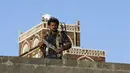 Anggota kelompok militan kelompk houthi  melakukan penjagaan selama demonstrasi tentang serangan Arab Saudi, Jumat, (20/11). Houthi merupakan sebuah kelompok atau gerakan yang awalnya hanya mengajarkan toleransi dan perdamaian. (REUTERS/Khaled Abdullah)