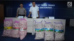 Wadir Tipideksus Polri, Kombes Pol Daniel Tahi Monang Silitonga (kanan) melihat barang bukti jelang rilis penyalahgunaan distribusi bawang putih impor di Jakarta, Kamis (31/5). DirTipideksus mengamankan 30.000 ton. (Liputan6.com/Helmi Fithriansyah)