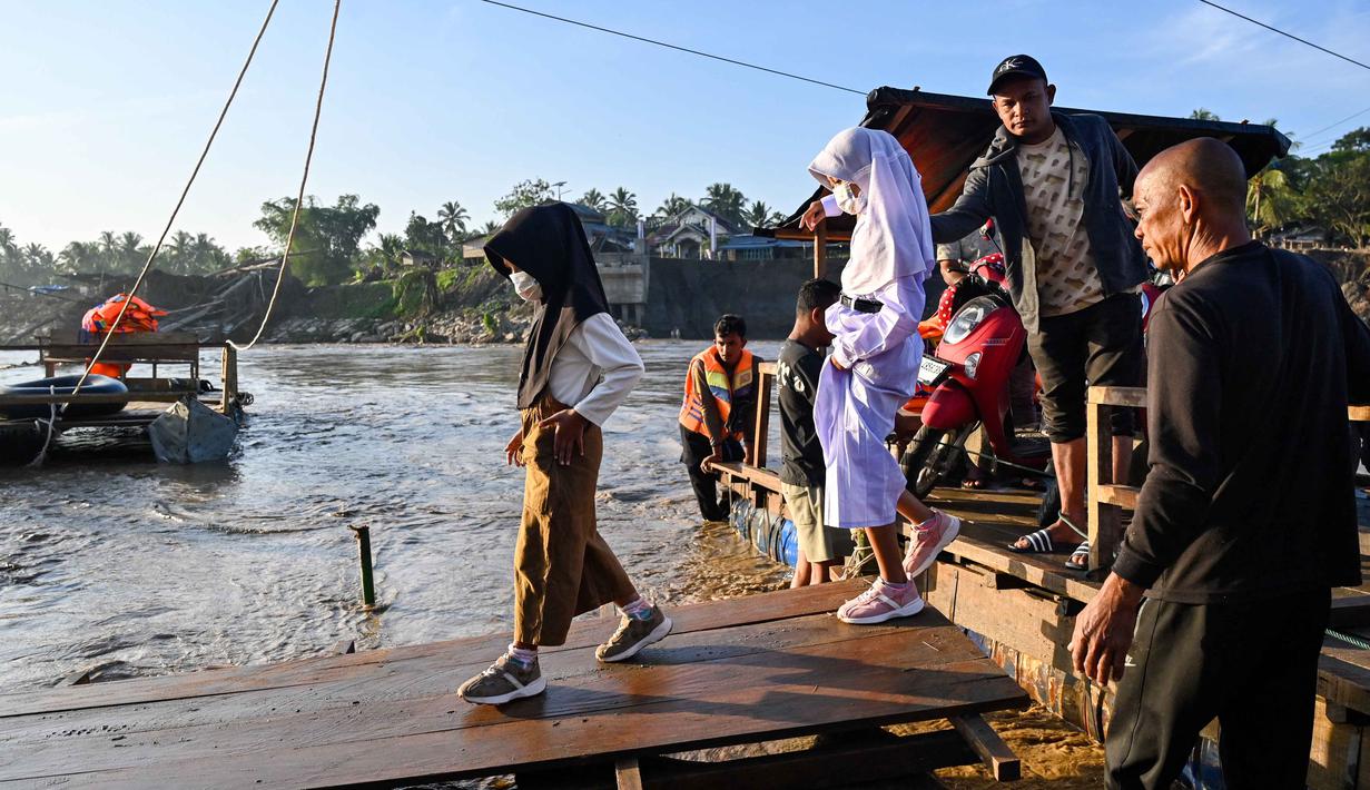 Ketetapan tersebut tertuang dalam Surat Edaran bernomor 400.3/2026 yang ditandatangani Kepala Dinas Pendidikan dan Kebudayaan Kabupaten Bireuen, dan ditujukan kepada seluruh Kepala UPTD PAUD, SD, dan SMP. Tampak dalam foto, sejumlah siswa menaiki perahu darurat untuk menyeberangi Sungai Peusangan pasca banjir bandang yang menghancurkan desa-desa di sekitarnya di kabupaten Bireuen, provinsi Aceh, Indonesia pada Senin 5 Januari 2026. (CHAIDEER MAHYUDDIN/AFP)