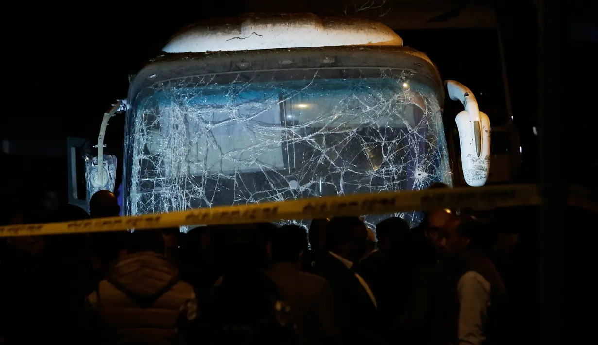 Pasukan keamanan berdiri di dekat sebuah bus wisata setelah serangan bom pinggir jalan di sebuah daerah dekat Piramida Giza di Kairo, Mesir (28/12). Insiden tersebut menewaskan  dua turis Vietnam dan 12 lainnya terluka. (AP Photo/Nariman El-Mofty)