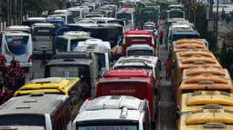 Banyaknya bus-bus yang mengangkut ratusan buruh parkir di badan jalan mengakibatkan kemacetan di kawasan Sudirman, Jakarta, Kamis (1/5/14). (Liputan6.com/Johan Tallo)