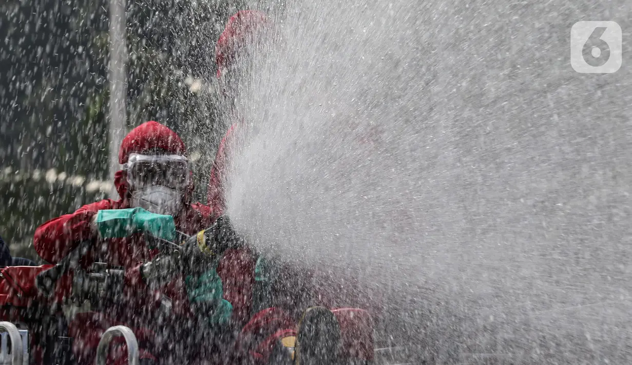Petugas menyemprotkan cairan disinfektan di Kompleks Parlemen, Jakarta, Minggu (9/8/2020).  DPR/MPR akan memasuki persiapan Rapat Paripurna terbuka DPR RI tahun 2020 dengan acara Pidato Kenegaraan Presiden RI dan Pengantar keterangan Pemerintah atas RAPBN tahun 2021. (Liputan6.com/Johan Tallo)