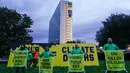 Aktivis organisasi lingkungan Greenpeace membuka spanduk di samping gedung kantor pusat ENI—perusahaan minyak dan gas Italia—di Roma, Italia, Selasa, 5 Desember 2023. (AP Photo/Andrew Medichini)