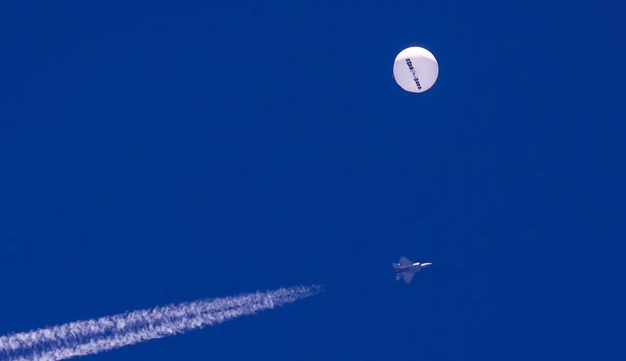 Balon mata-mata China terbang di atas Samudra Atlantik sementara jet tempur terlihat di bawahnya, South Carolina, Amerika Serikat, 4 Februari 2023. Tiga bandara dan wilayah udara ditutup di lepas pantai Carolina Utara dan Selatan saat militer melakukan operasi tersebut. (Chad Fish via AP)