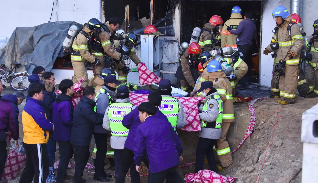 Petugas pemadam kebakaran mengevakuasi jasad korban kebakaran rumah sakit Sejong di Milyang, Korea Selatan, Jumat (26/1). Mereka yang telah dievakuasi kini dirawat di empat rumah sakit berbeda yang letaknya tak jauh dari lokasi. (YONHAP / AFP)