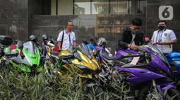 Polisi memberi label pada motor gede milik tersangka Quotex, Doni Salmanan di halaman Bareskrim Polri, Jakarta, Senin (14/3/2022). Bareskrim Polri menetapkan Doni Salmanan sebagai tersangka kasus dugaan penipuan hingga tindak pidana pencucian uang (TPPU) platform Quotex. (Liputan6.com/Faizal Fanani)