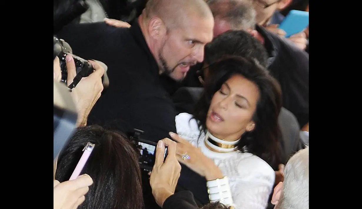 Kim Kardashian terlihat hampir jatuh ke tanah saat tiba-tiba diterjang seorang fans di Paris, (25/9/14). (Dailymail)
