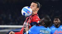 Penyerang AC Milan Zlatan Ibrahimovic (kiri) berebut bola dengan bek NapoliKalidou Koulibaly pada laga pekan ke-28 Liga Italia di Stadion Diego Armando Maradona, Senin dini hari WIB (7/3/2022). AC Milan kalahkan Napoli 1-0 lewat gol tunggal Olivier Giroud. (Tiziana FABI/AFP)