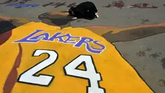 Seorang mahasiswi mencium gambar Kobe Bryant di Shenyang Sport University, Shenyang, China, (14/4/2016), untuk menghormati Kobe Bryant yang pensiun setelah 20 tahun bermain di NBA. (AFP)