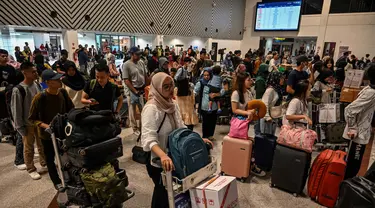 Calon penumpang melakukan lapor masuk di Bandara Internasional Juanda Surabaya di Sidoarjo, Jawa Timur, Sabtu 6 April 2024. (JUNI KRISWANTO/AFP)
