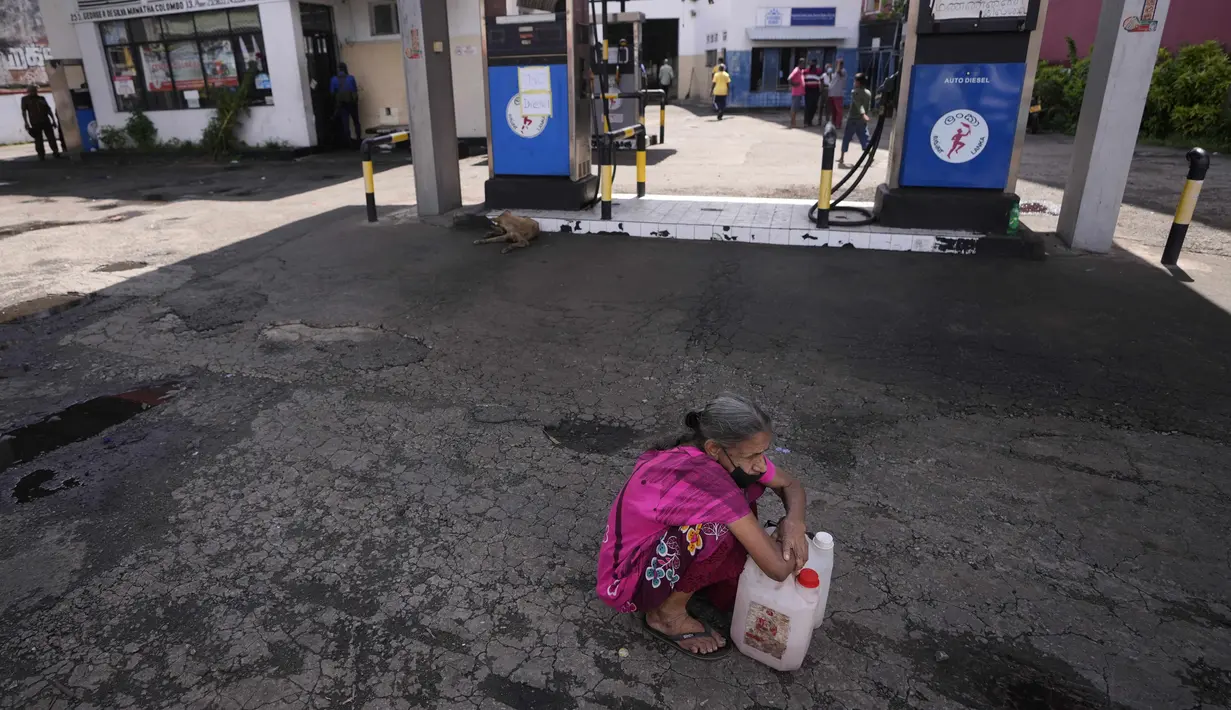 Seorang perempuan Sri Lanka menunggu di pompa bensin yang sepi, berharap untuk membeli minyak tanah untuk memasak di Kolombo, Kamis (26/5/2022). Ada kekurangan banyak barang kebutuhan , mulai dari makanan, gas untuk memasak, obat-obatan dan bahan bakar hingga kertas toilet dan korek api. (AP Photo/Eranga Jayawardena)