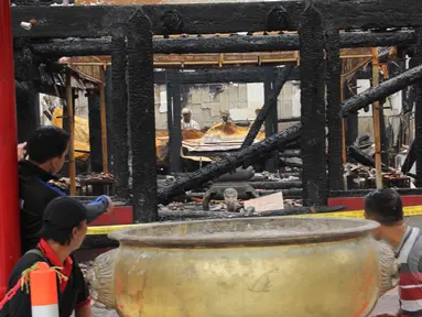 Sejumlah warga duduk di sekitar sisa-sisa kebakaran Wihara Dharma Bakti, Petak Sembilan, Jakarta, Kamis (19/3/2015). Wihara yang lebih dikenal dengan Petak Sembilan ini terbakar pada 2 Maret 2015 lalu. (Liputan6.com/Helmi Afandi)