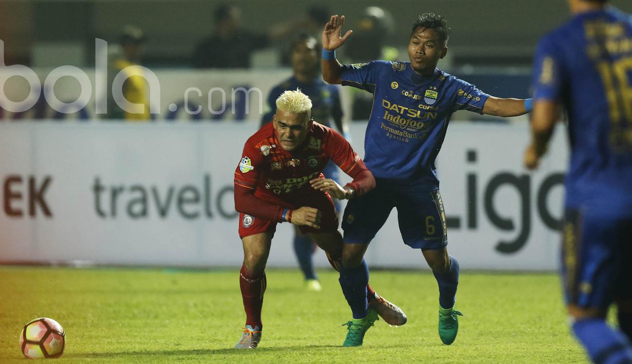 Striker Arema FC, Cristian Gonzales, terjatuh saat berebut bola dengan bek Persib Bandung, Tony Sucipto, pada laga Liga 1 di Stadion GBLA Bandung, Jawa Barat, Sabtu (15/4/2017). (Bola.com/M Iqbal Ichsan)