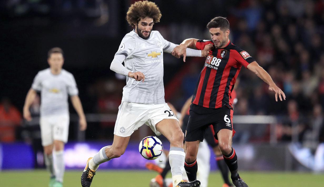 Pemain Manchester United, Marouane Fellaini saat berebut bola dengan pemain Bournemouth, Andrew Surman pada lanjutan Premier League di Vitality Stadium, Bournemouth, (18/4/2018). MU menang 2-0. (Adam Davy/PA via AP)