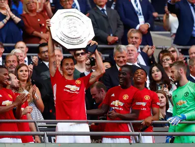 Penyerang MU, Zlatan Ibrahimovic mengangkat trofi bersama rekan-rekannya usai menjuarai Piala Community Shield di stadion Wembley, London, Inggris, (1/8). MU juara usai mengalahkan Leicester City dengan skor akhir 2-1. (Reuters/Eddie Keogh)