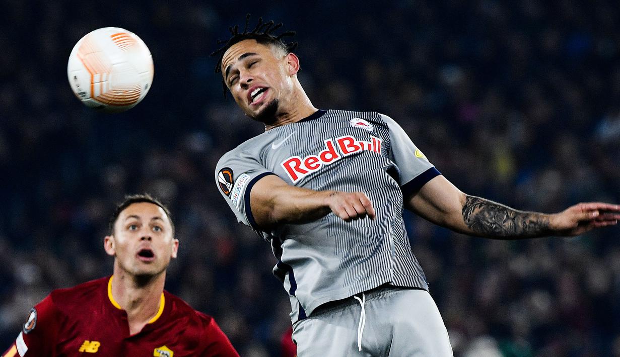 Pemain RB Salzburg, Noah Okafor berebut bola dengan pemain AS Roma pada laga play off leg kedua Liga Europa 2022/2023 di Olympic Stadium, Roma, 23 Februari 2023. Kesuksesan RB Salzburg yang saat ini menempati posisi puncak klasemen Liga Austria tak lepas dari peran Okafor. Ia tercatat telah melesatkan 10 gol dan 4 assist dari 28 laga. Liverpool dapat mendatangkan pemain berkebangsaan Swiss tersebut dengan harga terjangkau mengingat kontraknya tinggal 15 bulan lagi. (AFP/Filippo Monteforte)
Filippo MONTEFORTE / AFP