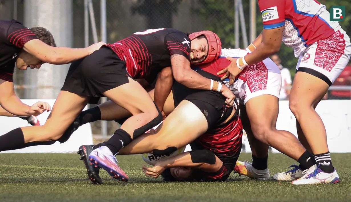 Sejumlah pemain tim rugby putra Singapura (kiri) berebut bola dengan pemain tim rugby putra Indonesia saat laga Asia Rugby Sevens Trophy 2022 yang berlangsung di GBK Rugby Field, Jakarta, Sabtu (06/08/2022). (Bola.com/Bagaskara Lazuardi)