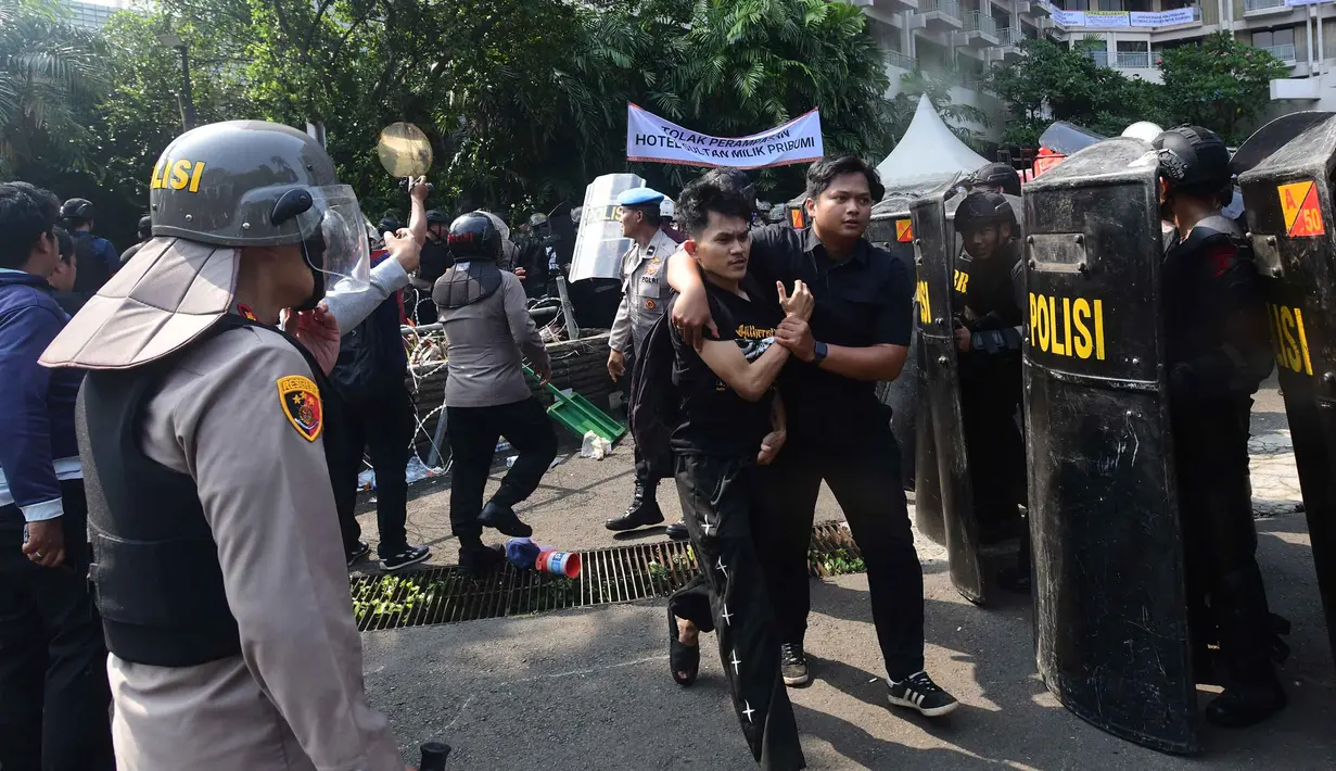 Polisi menangkap salah satu massa yang menolak eksekusi lahan Hotel Sultan saat bentrok dengan petugas pengamanan gabungan di kawasan Gelora Bung Karno (GBK), Jakarta, Kamis (18/6/2026). (merdeka.com/Arie Basuki)