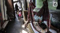 Seorang anak tertidur di atas ayunan buatan di permukiman padat penduduk di kawasan Cakung, Jakarta, Senin (15/2/2021). Jika dibandingkan dengan September 2019, jumlah penduduk miskin di perkotaan naik 1,32 persen, sedangkan di perdesaan naik 0,60 persen. (merdeka.com/Iqbal S Nugroho)