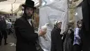 Yahudi Ultra-Ortodoks berbaris untuk mengikuti ritual Kaparot di Yerusalem (27/9). Praktik ritual itu dengan memegang pundak ayam dan memutar-mutarkan ke leher tiga kali. (AFP Photo/Manahem Kahana)