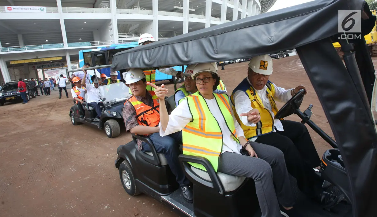 Menkeu Sri Mulyani dan Menteri PUPR Basuki Hadimuljono menaiki mobil golf saat meninjau Stadion Utama Gelora Bung Karno di Senayan, Jakarta, Kamis (23/11). Peninjauan untuk melihat progres dari renovasi venue Asian Games 2018. (Liputan6.com/Angga Yuniar)