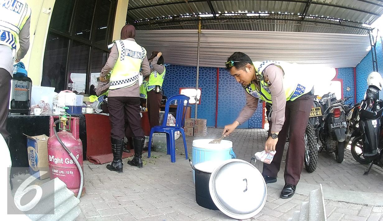 Anggota polisi  mengambil makan siang di pos pengamanan 06 exit tol Brebes Timur, Jawa Tengah, Sabtu (9/7). Anggota Satlantas Polres Brebes sedang mempersiapkan makanan siang untuk anggota kepolisian yang sedang bertugas. (Liputan6.com/Herman Zakharia)