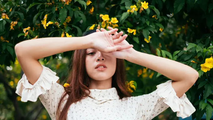 perempuan menutup wajah galau