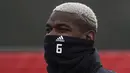 Paul Pogba mengenakan masker karena cuaca dingin saat sesi latihan di Aon Training Complex, Manchester, (15/2/2017). Manchester United akan melawan Saint-Etienne pada leg pertama 32 besar Liga Europa.  (AFP/Oli Scarff)