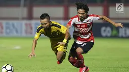 Pemain depan Bhayangkara FC, Sani Rizki Fauzi (kiri) berebut bola dengan Bek Madura United, Andik Rendika Rama pada lanjutan Go-Jek Liga 1 Indonesia 2018 bersama Bukalapak di Stadion PTIK, Jakarta, Kamis (7/6). (Liputan6.com/Helmi Fithriansyah)