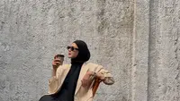OOTD ngopi Paula terlihat kece dengan paduan t-shirt, rok panjang, dan blazer nude. Ditutup dengan hijab lilit dan sunglasses [@paula_verhoeven]