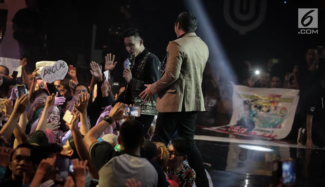 Fildan menyapa penonton saat duet dengan Pasha Ungu dalam Grand Final Dangdut Academy 4 atau D'Academy 4 di Studio 5 Indosiar, Jakarta, Jumat (19/5). (Liputan6.com/Faizal Fanani)