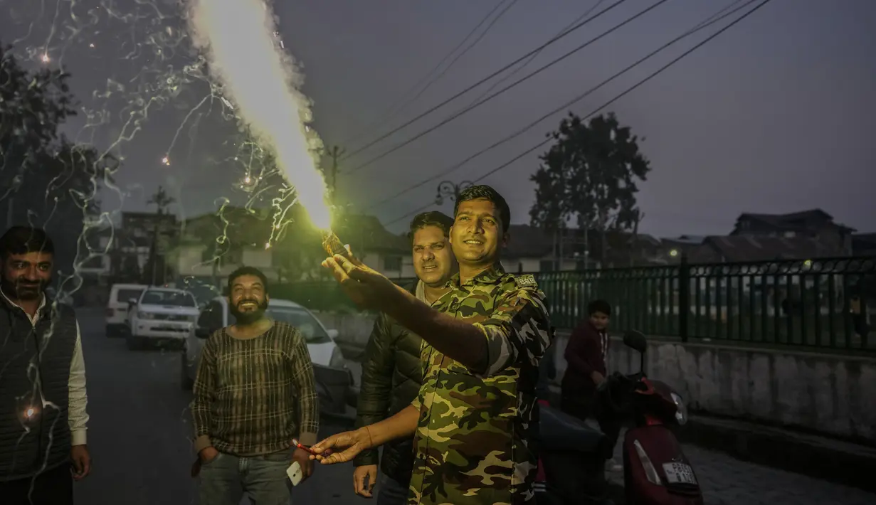 Seorang tentara paramiliter India membakar petasan untuk merayakan Diwali, festival cahaya Hindu di Srinagar, India, Senin (24/10/2022). Orang India di seluruh negeri merayakan Diwali, festival Hindu yang melambangkan kemenangan terang atas kegelapan. (AP Photo/Mukhtar Khan)
