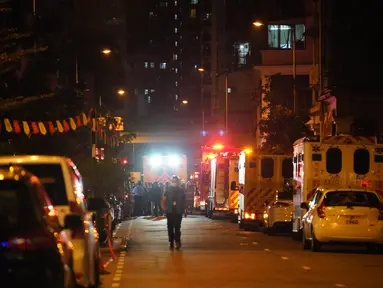 Petugas pemadam kebakaran dan polisi menyelidiki lokasi kebakaran di Hong Kong, China selatan (15/11/2020). Sebanyak tujuh orang tewas dan lebih dari 10 lainnya terluka setelah kebakaran melalap sebuah gedung apartemen di Hong Kong pada Minggu (15/11) malam, menurut kepolisian. (Xinhua/Lui Siu Wai)