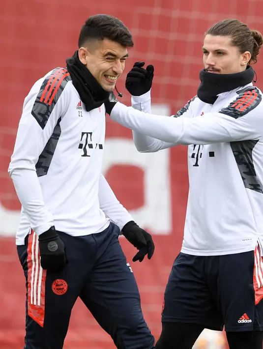 Gelandang Bayern Munchen, Marcel Sabitzer (kanan) bercanda dengan rekan setimnya Marc Roca selama sesi latihan di Munich, Jerman, Selasa (5/4/2022). Munchen akan bertanding melawan Villarreal pada leg pertama perempat final Liga Champions. (AFP/Christof Stache)