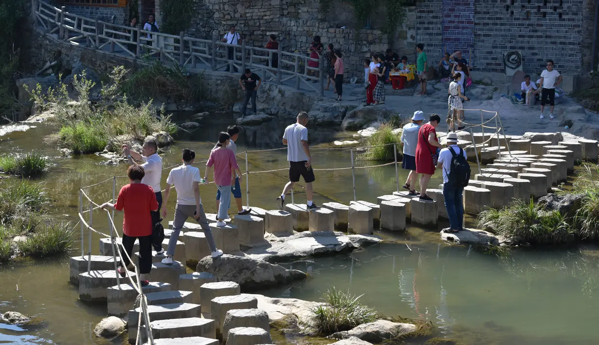 Para wisatawan mengunjungi objek wisata Kota Furong di Wilayah Yongshun, Provinsi Hunan, China tengah (2/8/2020). Dengan menerapkan sejumlah langkah pencegahan epidemi, objek wisata tersebut mencatat peningkatan kunjungan turis selama liburan musim panas. (Xinhua/Chen Sihan)