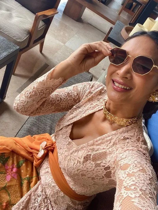 Berfoto selfie, Happy Salma memamerkan kebaya brokatnya yang berwarna cokelat. Penampilannya lengkap dengan selendang cokelat yang dililitkan di perut dan kain sebagai bawahan. Ia juga mengenakan aksesori kalung dan anting-anting emas, serta sunglasses. Foto: Instagram.