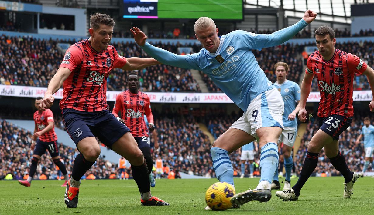 Pemain Manchester City, Erling Haaland, berusaha melepaskan diri dari adangan pemain Everton pada laga Premier League 2023/2024 pekan 24 di Stadion Etihad, Sabtu (10/2/2024). (AFP/Darren Staples)