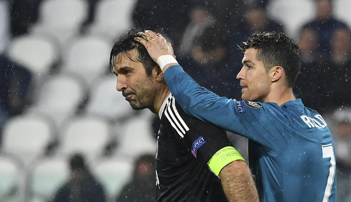 Pemain Real Madrid, Cristiano Ronaldo (kanan) memegang kepala kiper Juventus, Gianluigi Buffon usai laga  leg pertama Liga Champions di Allianz Stadium, Turin, (3/4/2018). Ronaldo mencetak dua gol ke gawang Juventus. (AFP/Alberto Pizzoli)