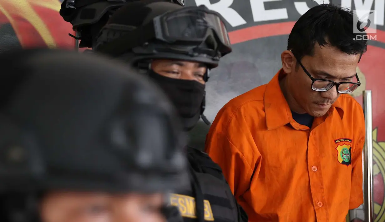 Tersangka pencurian dan pembunuhan sadis terhadap Jeanne Setyadi (78) tertunduk di Polda Metro Jaya, Jakarta, Kamis (26/7). Nenek Jeanne ditemukan tak bernyawa dengan kondisi tertelungkup di lantai. (Liputan6.com/Immanuel Antonius)