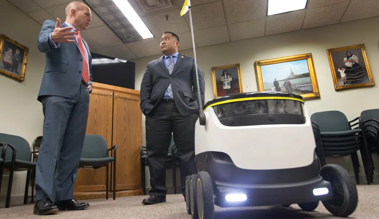Ketua House Transportation Committee, Del. Ron Villanueva (kanan) sedang berbicara dengan kliennya, David Catania saat uji coba Robot Pengirim di Virginia, AS (25/1). (AP Photo/Steve Helber)