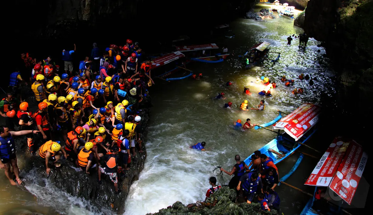 Sejumlah pengunjung memadati lokasi wisata Green Canyon di Desa Kertayasa, Kecamatan Cijulang, Ciamis, Jawa Barat, Sabtu (17/5/2015). Nama asli Green Canyon adalah Cukang Taneuh yang berarti jembatan tanah. (Liputan6.com/Andrian M Tunay)