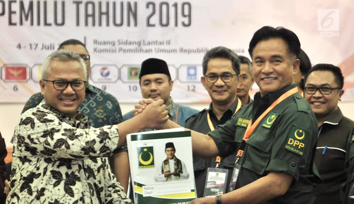 Ketua Umum Partai Bulan Bintang (PBB) Yusril Izha Mahendra (kanan) menyerahkan berkas bakal caleg ke Ketua KPU Arif Budiman di Gedung KPU, Jakarta, Selasa (17/7). PBB daftarkan 490 bakal caleg. (Merdeka.com/Iqbal S Nugroho)