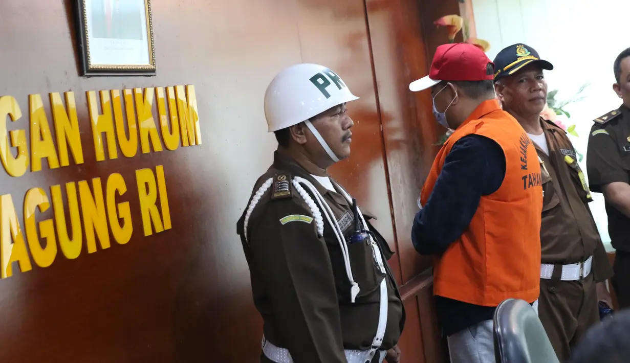 Buronan koruptor Atto Sakmiwata Sampetoding (tengah) diperlihatkan petugas di Gedung Kejaksaan Agung, Jakarta, Kamis (21/11/2019). Kejagung bersama Ditjen Imigrasi dan KBRI Kuala Lumpur memulangkan buronan koruptor Rp 24 miliar yang telah divonis 5 tahun penjara. (Liputan6.com/Helmi Fithriansyah)