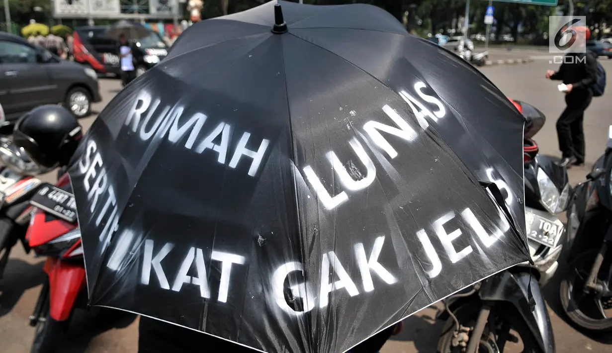Aksi massa dari Komite Warga Sentul City mengenakan payung hitam di depan Istana Negara, Senin (30/4). Mereka meminta proses hukum terhadap pengembang perumahan Sentul City karena diduga terjadi penguasaan pengelolaan air. (Merdeka.com/Iqbal Nugroho)